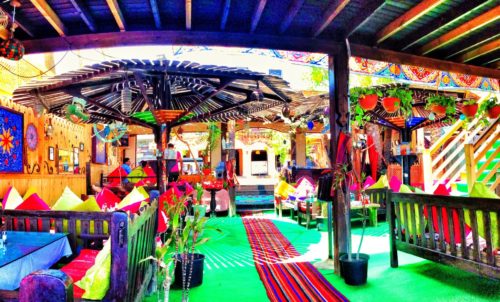 Colorful indoor/outdoor restaurant located in Dahab, Egypt featuring dozens of benches covered in colorful pillows