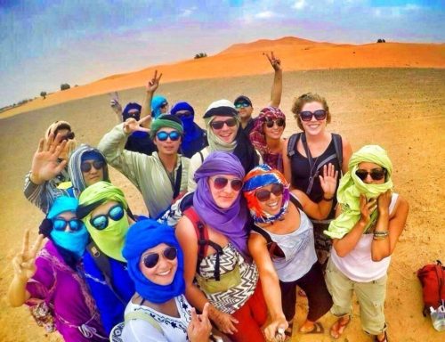 Preparing to ride camels into the Sahara Desert with head coverings.