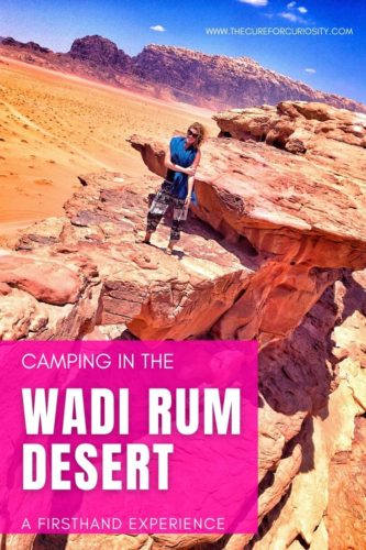 Camping in the Wadi Rum Desert: A Firsthand Experience with a natural red rock bridge with a female standing on it