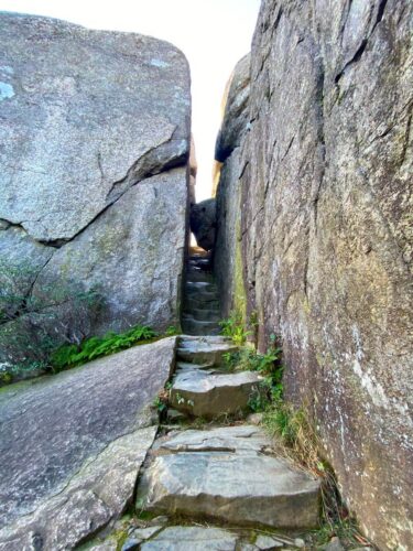Narrow rock crevasse to climb in and under boulders on the way up the mountain
