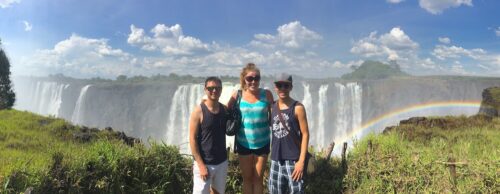 Friends posing in front of Victoria Falls at Victoria Falls National Park, Zimbabwe