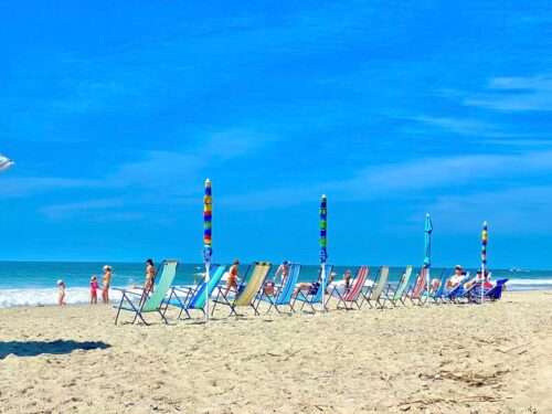 Colorful chairs set up in a row on the beach