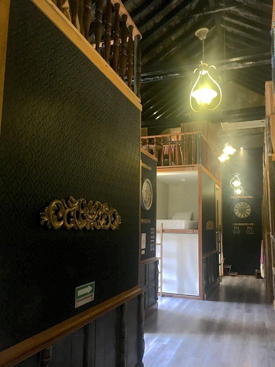 Interior of a hostel with vintage lighting and wooden furnishings.