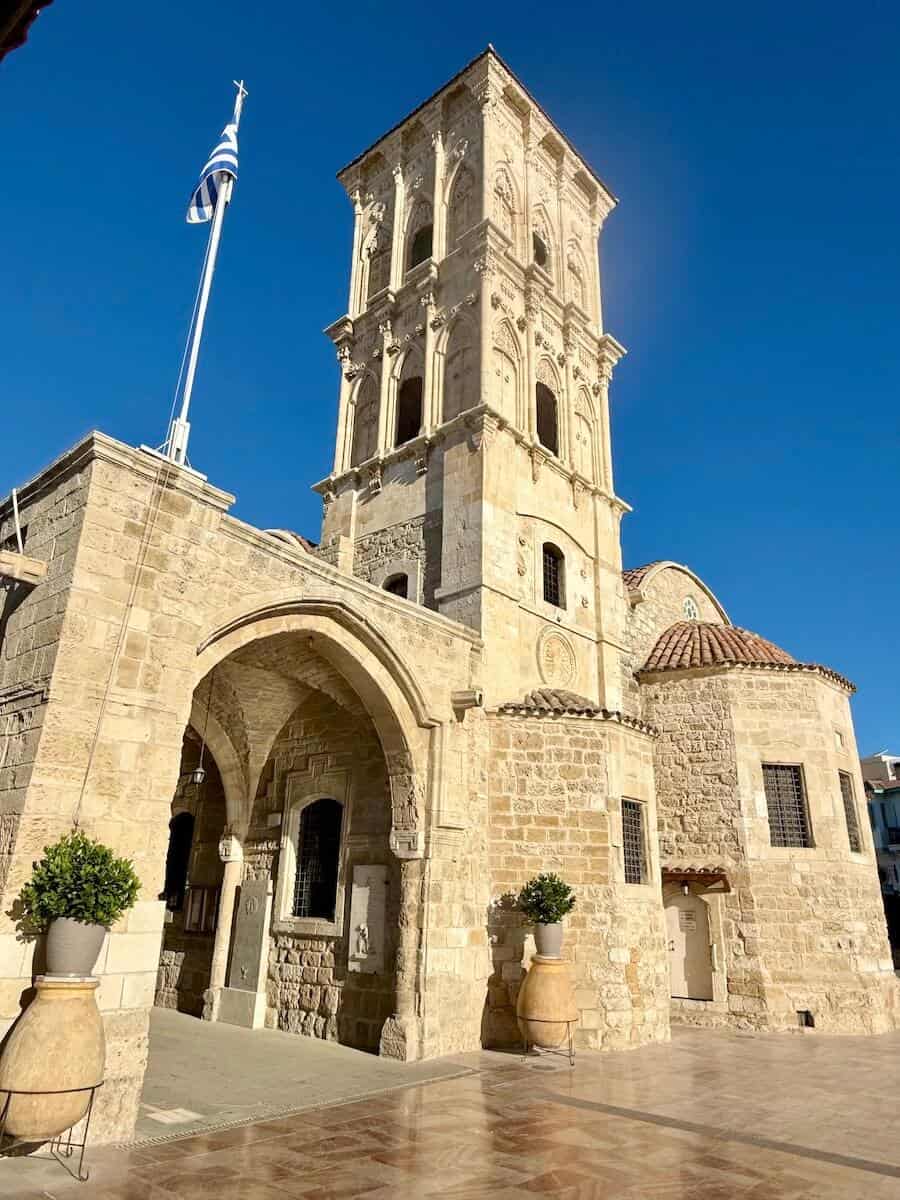 Ancient stone bell tower in Cyprus with clear blue sky.