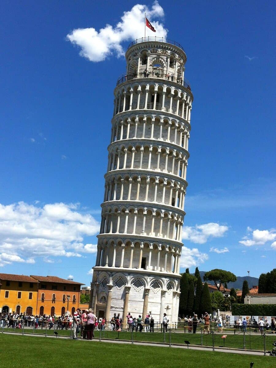 Iconic Leaning Tower of Pisa under a blue sky with clouds.
