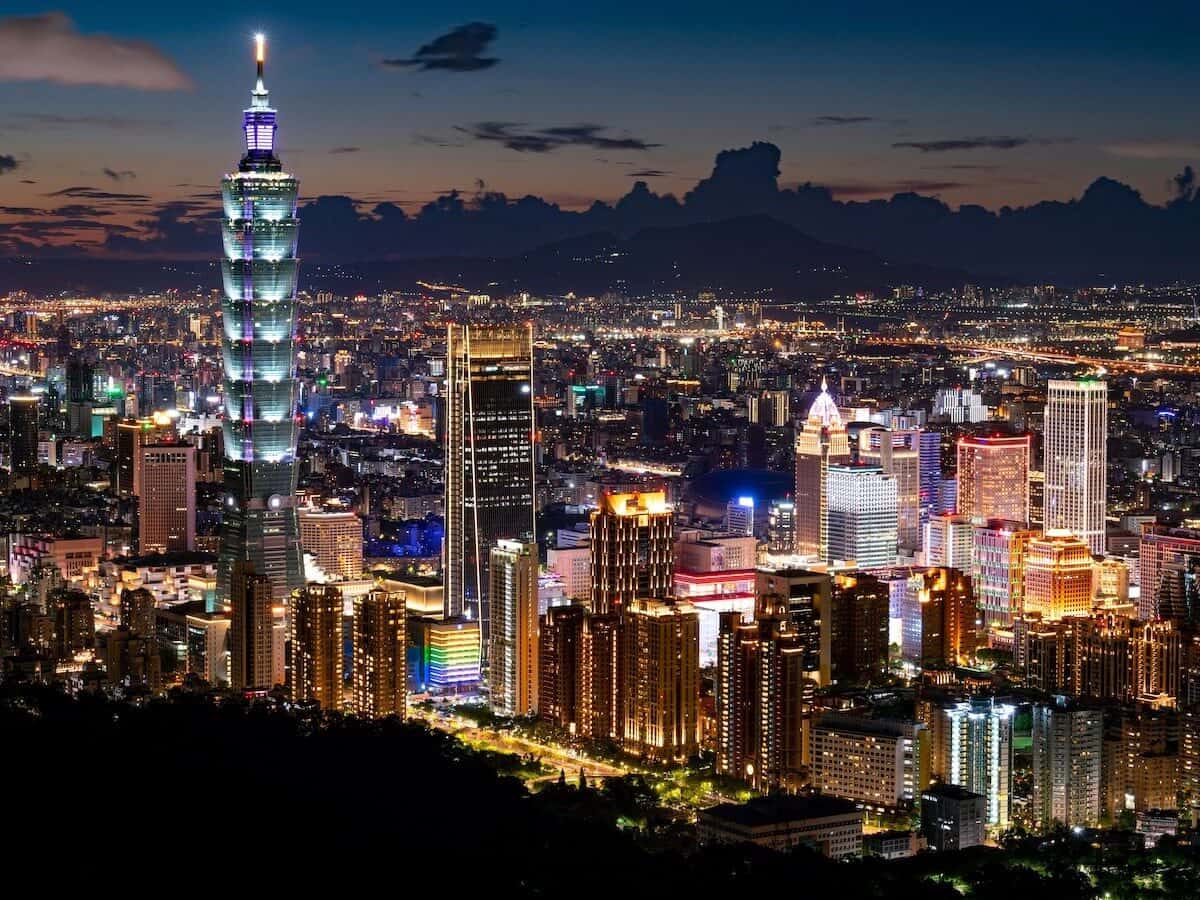 Night view of Taipei 101 and Taipei city skyline with illuminated buildings.